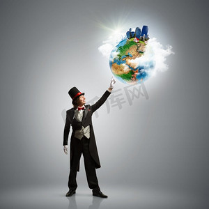 魔术师与地球图像魔术师在帽子举行地球仪。生态概念。这张图片的元素是由美国宇航局提供的