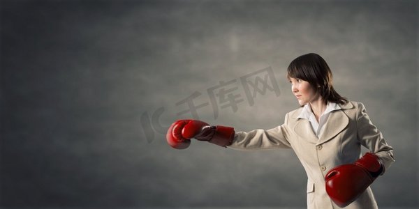 她是个斗士。戴着红拳手套的年轻女商人准备好了