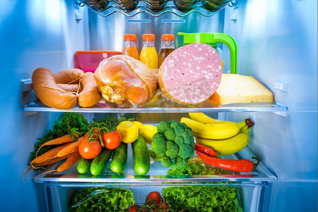 冰箱里的水果摄影照片_敞开的冰箱里装满了食物。
