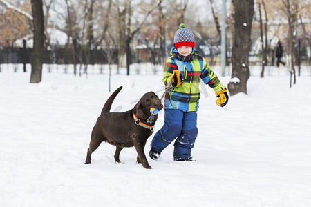 朋友友摄影照片_学龄儿童带着狗在冬季公园。我和我最好的朋友