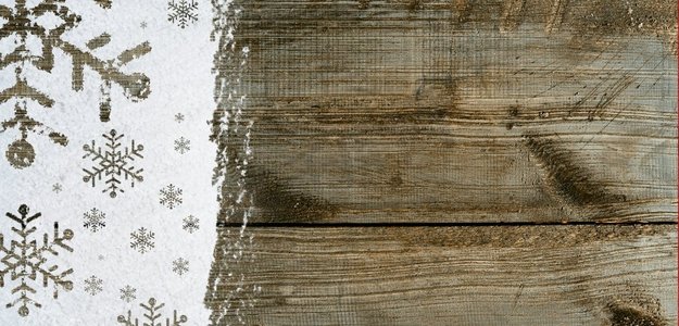 关于雪的新年背景。圣诞卡或新年背景由雪花制成，手写在雪地和木桌上