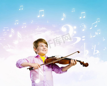 小提琴手。小可爱的男孩形象小提琴演奏反对彩色背景