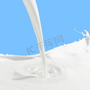 流体彩色摄影照片_倒牛奶水花。在彩色背景上浇上白牛奶水花