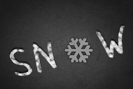 白雪这个词。混凝土背景上的雪字，用雪花代替字母O