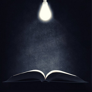 书和台灯摄影照片_打开书本。挂在上面的旧翻开的书和灯