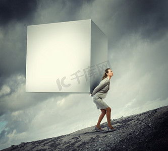 大白形象摄影照片_女商人背着立方体。女商人背着大白方块的形象。文本的位置