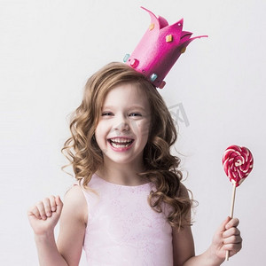 艾莎公主摄影照片_糖果小公主。美丽的小糖果公主，戴着皇冠，手持大粉心棒棒糖，微笑着