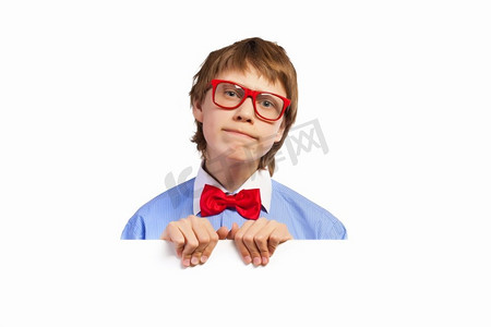 戴着红色眼镜的学生拿着白色的正方形。图像困惑的男孩举行白色广场。广告位