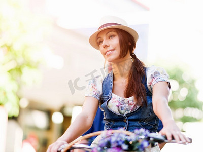 骑自行车的美女。美丽的年轻女子在城市里骑自行车