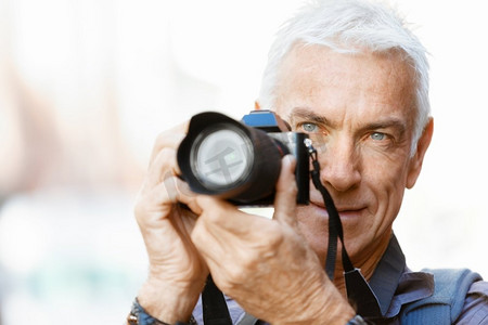 拿着照片摄影照片_在城市里拿着相机的老年男子。寻找好的萌芽