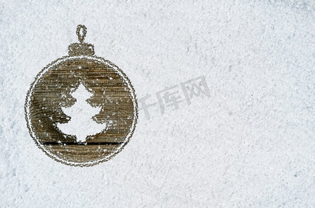 关于雪的新年背景。圣诞卡或新年背景，由手写在雪地和木桌上的装饰球符号制成