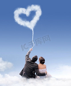 刚刚结婚的夫妇坐在毛茸茸的云上