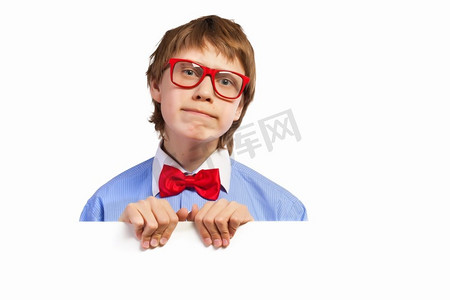 红白色海报摄影照片_戴红眼镜的男生手持白色方块。迷茫的男孩拿着白色方块的形象。刊登广告的地点