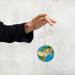 自然和人类。人类用绳索牵着地球的手的特写。这张图片的要素由美国宇航局提供