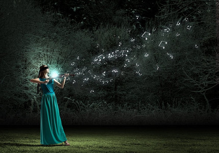 Virtuoso小提琴女球员在绿色连衣裙。迷人的小提琴家