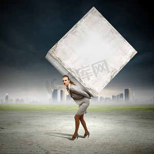 大白形象摄影照片_女商人背着立方体。女商人背着大白方块的形象。文本的位置