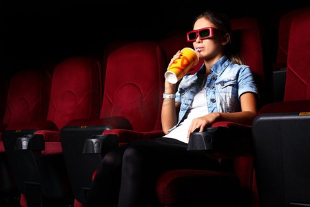 一个年轻的女孩在电影院看电影