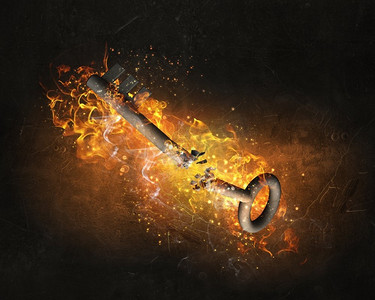 火焰中的钥匙标志。钥匙作为安全或成功的象征，在黑暗的背景下燃烧