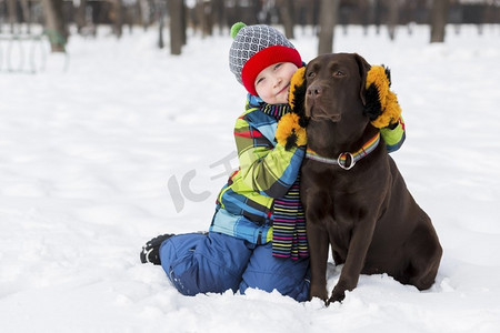 朋友友摄影照片_学龄儿童带着狗在冬季公园。我和我最好的朋友