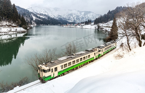 火车与冬季景观雪和湖上的村庄
