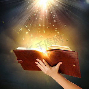 魔法书一种人手手持的带有魔法灯的魔法书