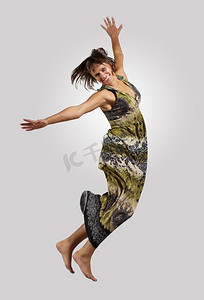 古女子摄影照片_年轻女子又跳又跳……非常现代、苗条的嘻哈风格的女人在彩色背景上跳着舞