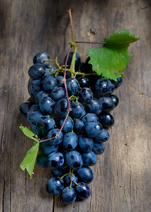 木桌背景上的一串红葡萄