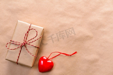 情人节用手工纸包裹的心形礼盒和红色的蝴蝶结