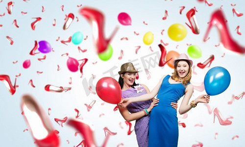 准备一个很棒的派对。两名年轻女子身穿休闲服，手持彩色气球庆祝