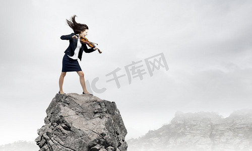 女商人与小提琴。年轻坚定的女子在黑色西装演奏小提琴