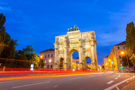 黄昏时分，慕尼黑的西格斯特胜利拱门，车辆在拱门周围穿梭。