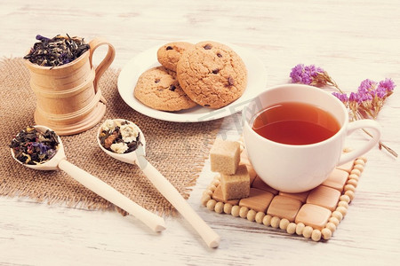 花草茶和饼干。木桌上摆着各式凉茶