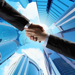 商务握手。与摩天大楼握手的特写图像