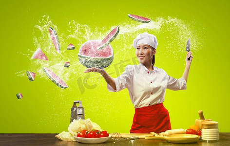 亚洲女厨师用刀。亚洲女性厨师与刀切水果和蔬菜在空气中