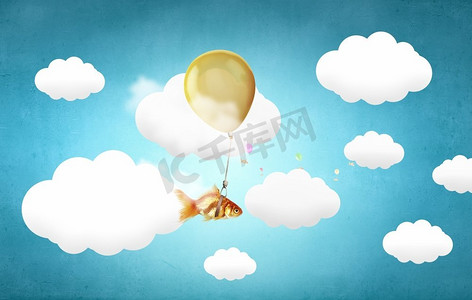 金鱼在气球上飞翔。绑在大气球上的金鱼在空中飞翔