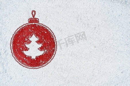 新年雪地摄影照片_关于雪的新年背景。圣诞卡或新年背景，由手写在雪地和红色工艺纸上的装饰球符号制成