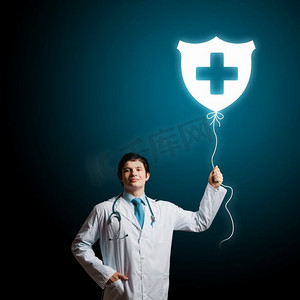 男医生。年轻男医生手持带有医学标志的气球。保健员