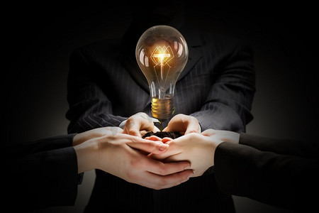 通力合作。集思广益和团队合作的概念，不同的商务人士手持灯泡