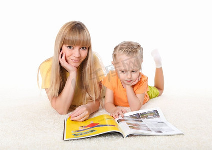 母亲读书摄影照片_年轻的母亲在地毯上给她的小女儿读书