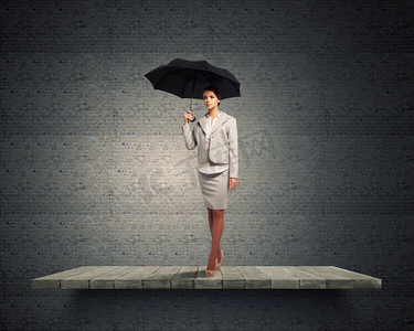 带伞的女人年轻漂亮的女商人在西装与黑色雨伞 