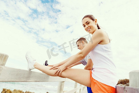 跑步情侣摄影照片_跑步者。一对年轻夫妇在海滩上锻炼和锻炼。跑步者。年轻夫妇一起在海滩上做运动