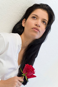 一位年轻漂亮的西班牙裔女子手持一朵玫瑰