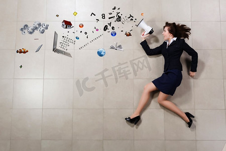 女发言人。滑稽的女实业家躺在地板拿着扩音器的女实业家