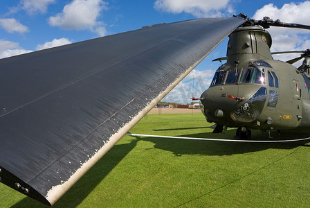 一架波音CH-47 Chinook，旋翼叶片全部绑紧，其中一片在前景中特写