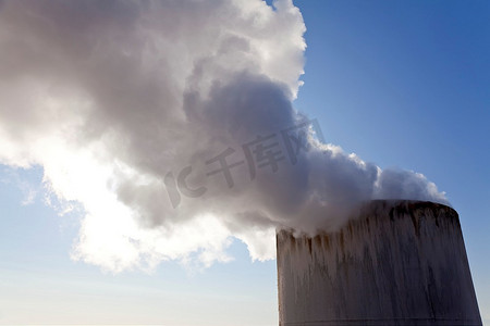 工业烟囱摄影照片_近距离拍摄烟囱顶部冒出的蒸汽或烟雾。
