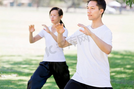 人们在公园练习太极拳。夏天在公园里练习太极的人们