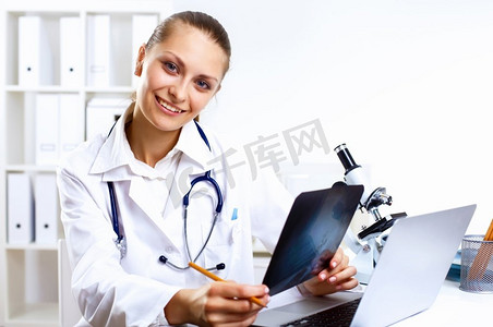 医务室背景摄影照片_友好的年轻女医生在医务室穿着制服