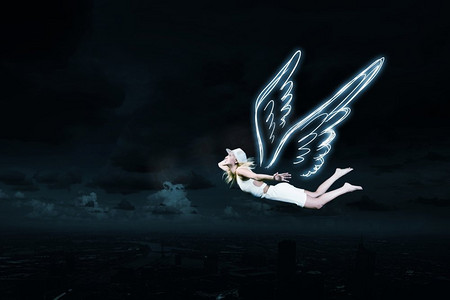 天使女孩飞得很高。在黑暗的天空背景上画着天使翅膀的可爱女孩