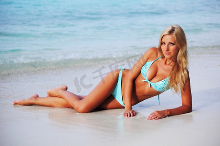 沙滩上的女人摄影照片_躺在海边沙滩上的女人