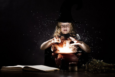 万圣节女巫。小万圣节女巫在锅上读魔术